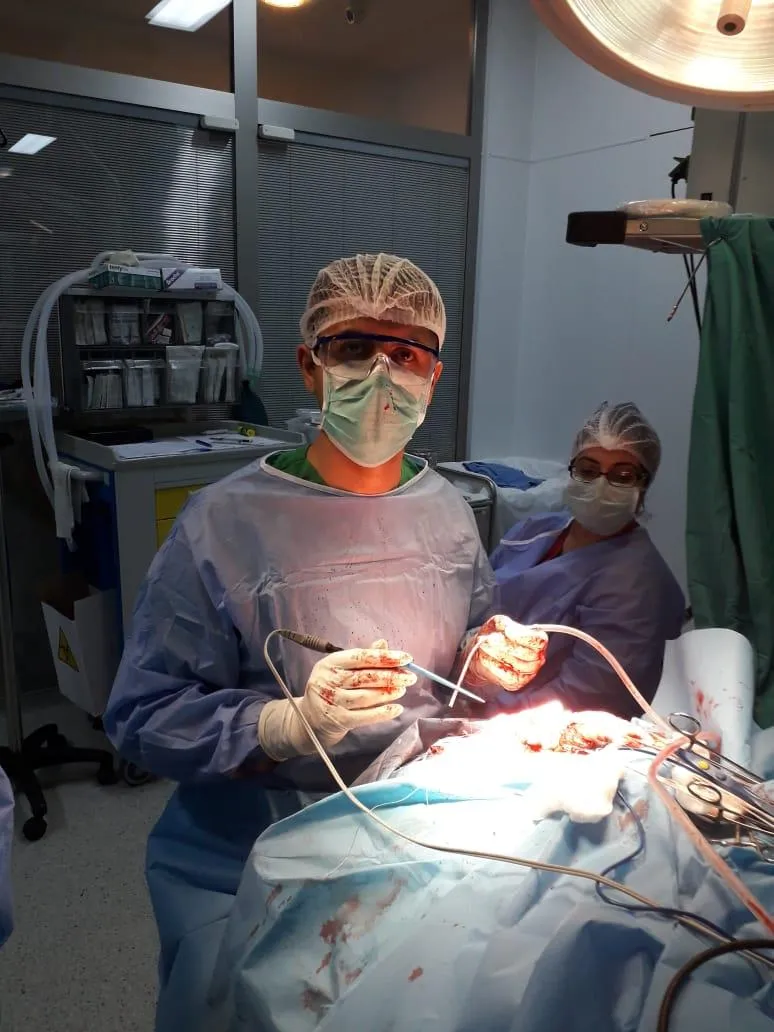 Böyüdücü eynək və baş işığı ilə əməliyyat, arxada tibb bacısı