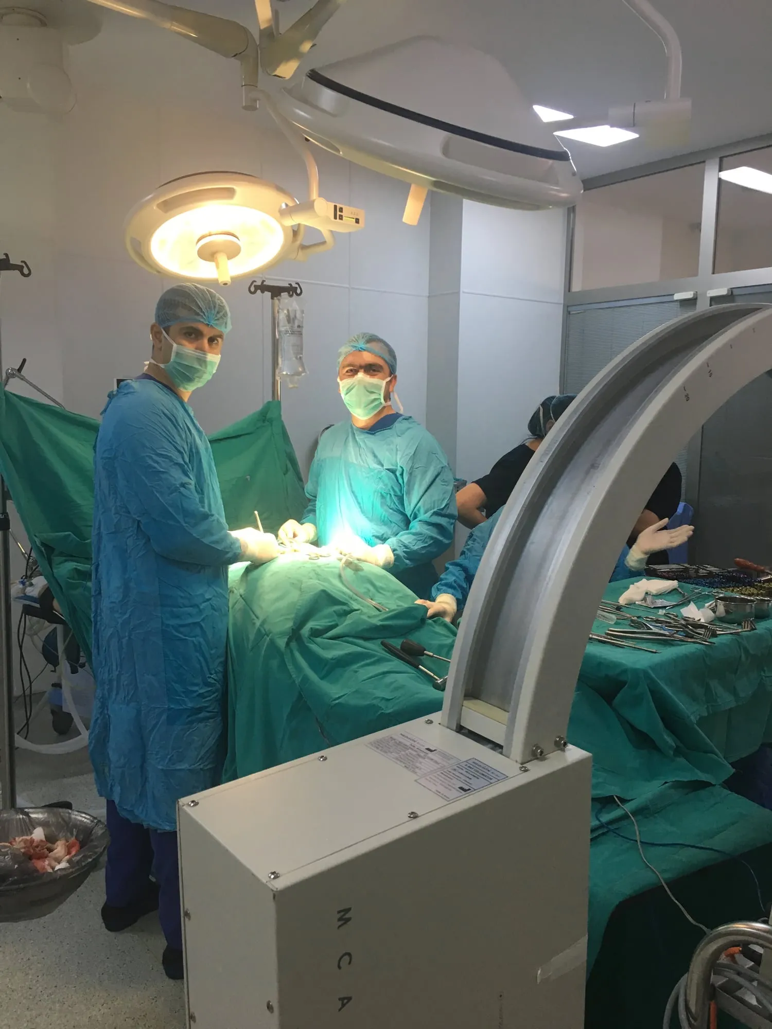 Əməliyyat komandası əməliyyatxanada, önündə rentgen aparatı