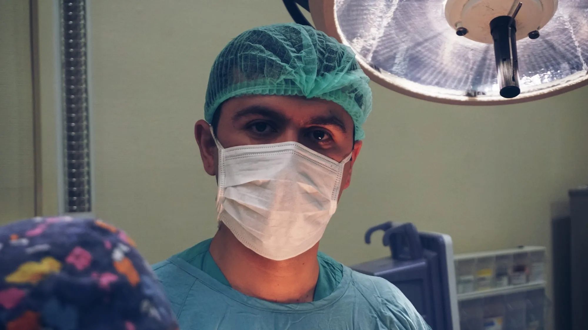 Dr. Ruslan Yunusov əməliyyatxanada, cərrahi maska və papaqla