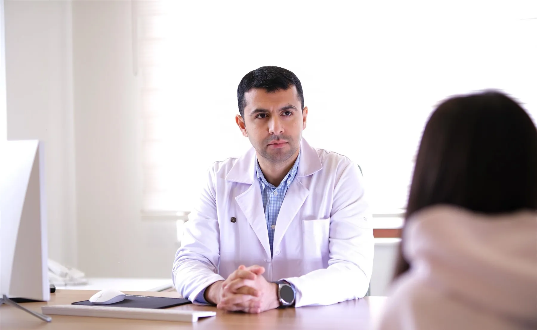 Dr. Ruslan Yunusov qəbulda xəstə ilə söhbət edir